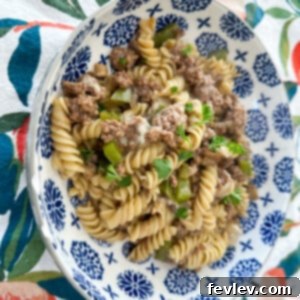 Delicious Philly Cheesesteak Pasta with ground beef, peppers, onions, and melted provolone
