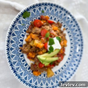 Delicious Beefy Potato Skillet in a pan, topped with cheese and fresh cilantro.