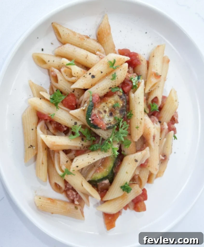 Bacon Tomato Pasta on a Budget 7 A bowl of freshly made Tomato Bacon Pasta garnished with fresh basil and Parmesan cheese.