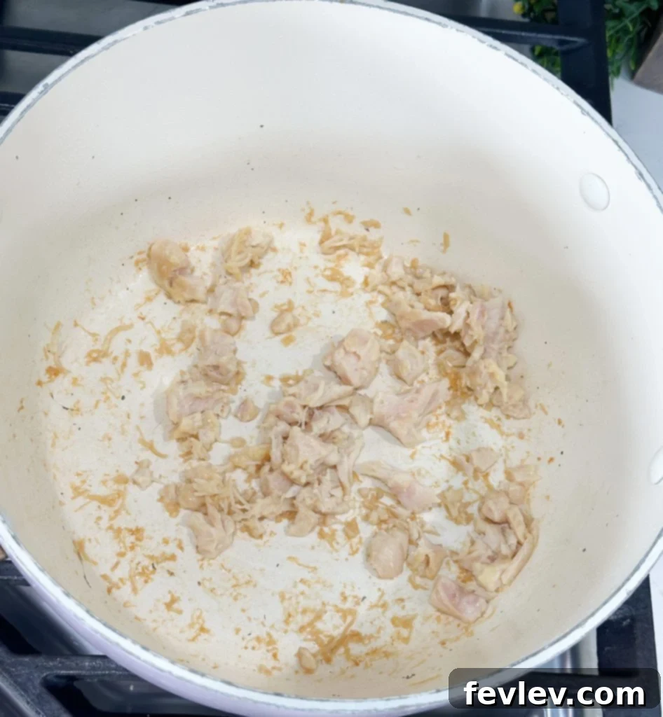 Budget-Friendly Chicken Broccoli Rice 4 Canned chicken being sautéed in olive oil in a large pot