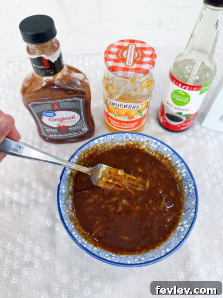 Mixing orange marmalade, BBQ sauce, and soy sauce for orange chicken sauce