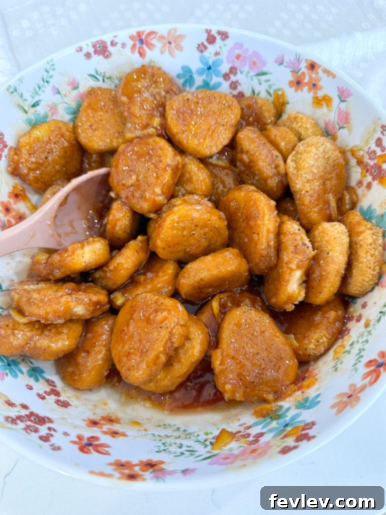 3-ingredient orange chicken served with rice and topped with sesame seeds