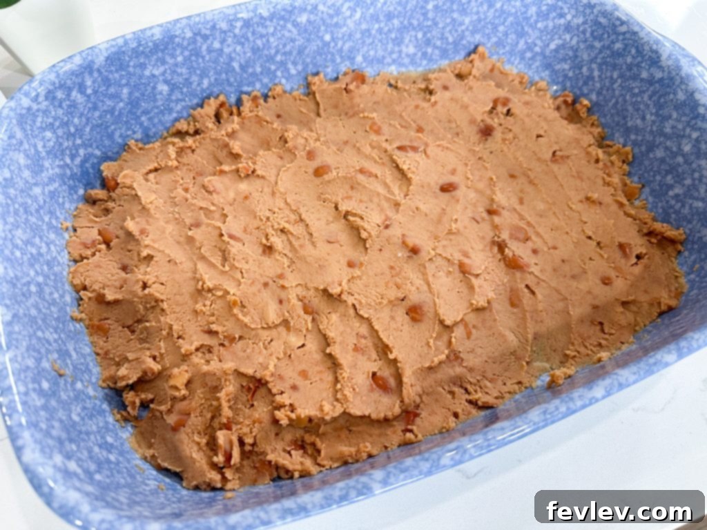 Lazy Day Taquito Bake 3 Greasing the baking dish for taquito casserole