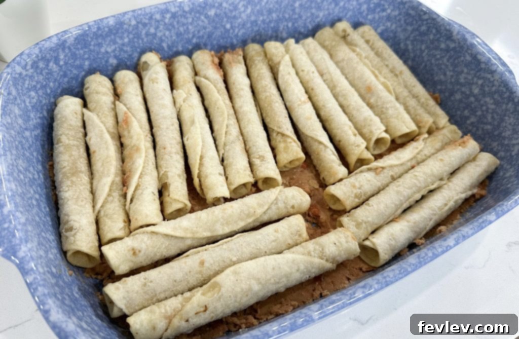 Lazy Day Taquito Bake 4 Spreading refried beans in baking dish for casserole