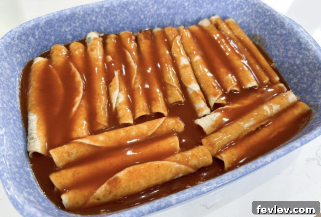 Lazy Day Taquito Bake 5 Layering frozen taquitos over refried beans