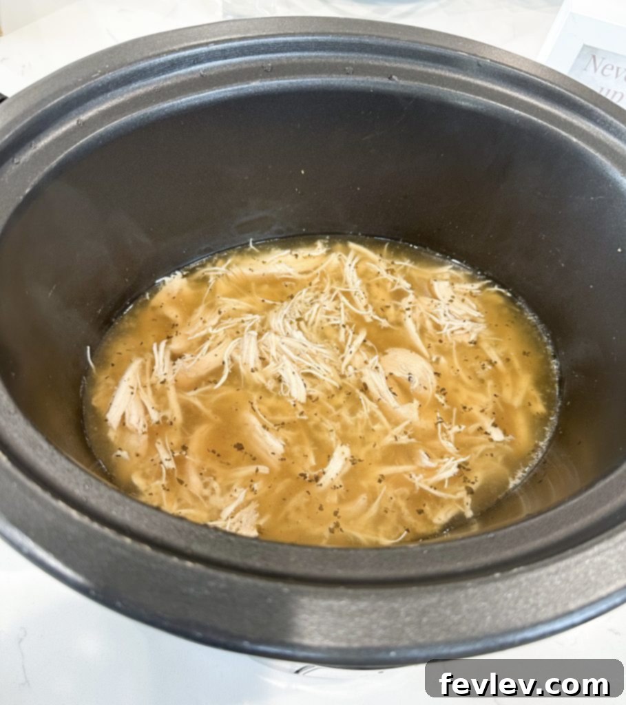 Comforting Slow Cooker Italian Chicken Noodle Soup 4 Preparing the creamy base with fresh spinach and cooked pasta for Italian chicken noodle soup.