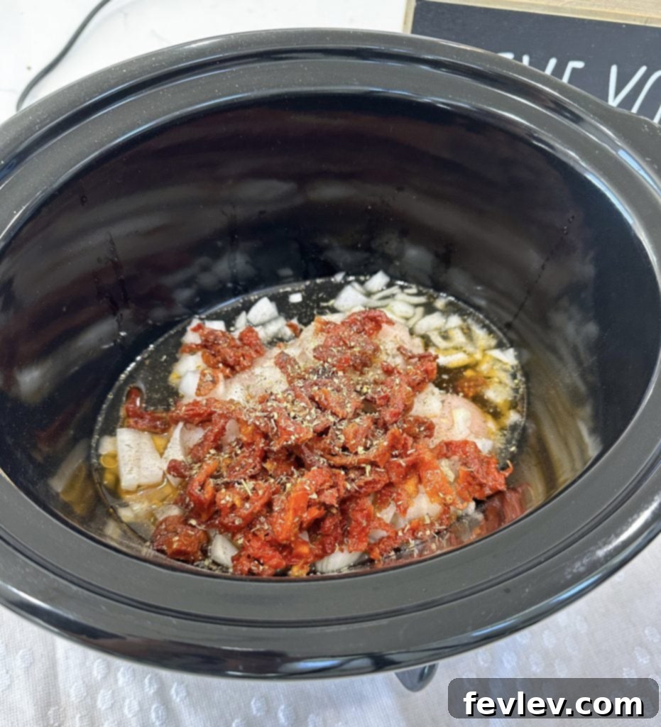 All initial ingredients for chicken and orzo mixed in slow cooker