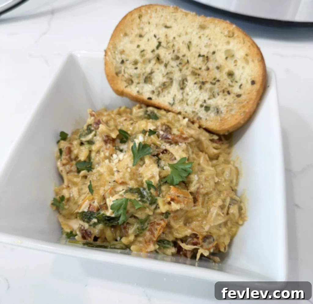 Slow cooker creamy chicken and orzo stored in a glass container