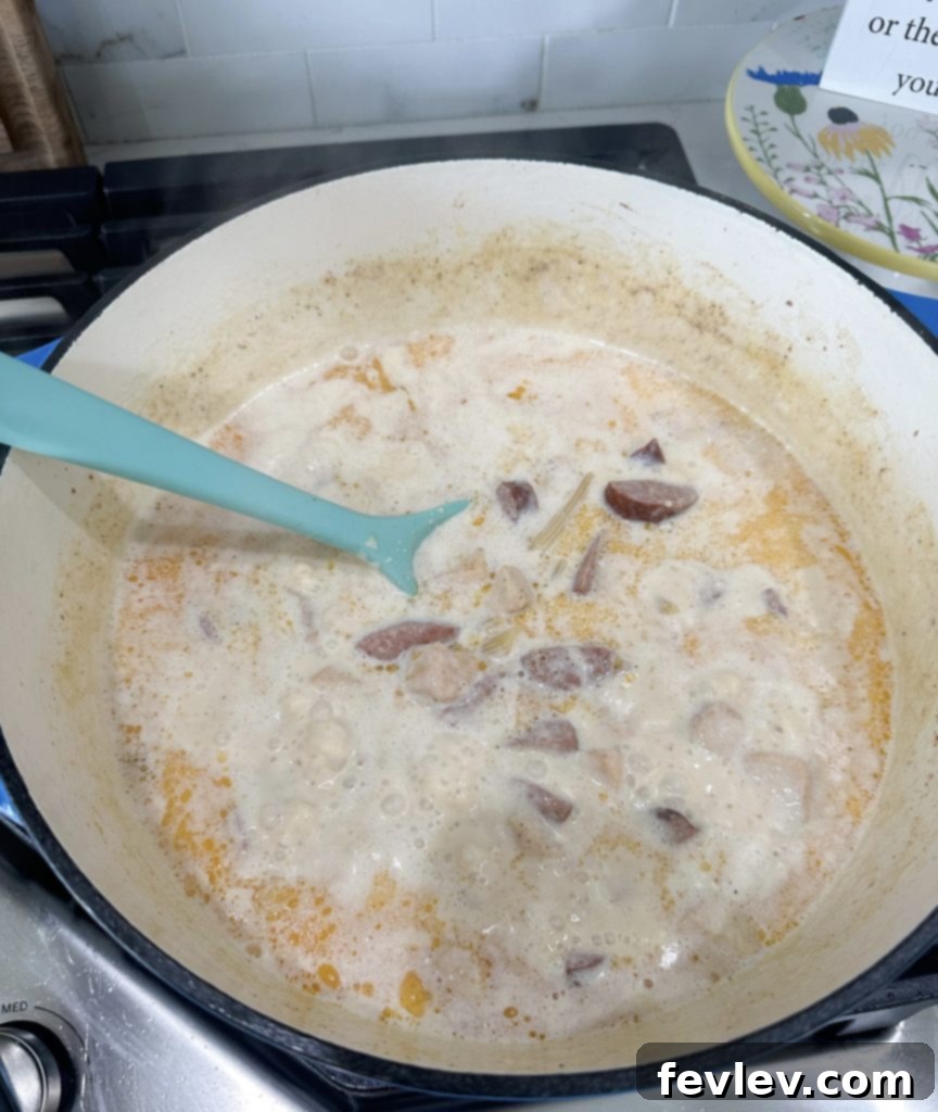 Searing chicken and kielbasa in a large pot for Cajun Chicken Alfredo
