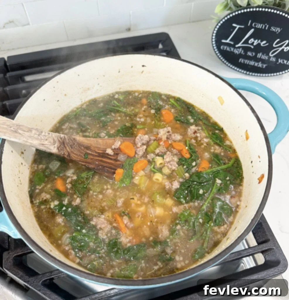 Ditalini pasta being added to the simmering Italian Sausage Soup