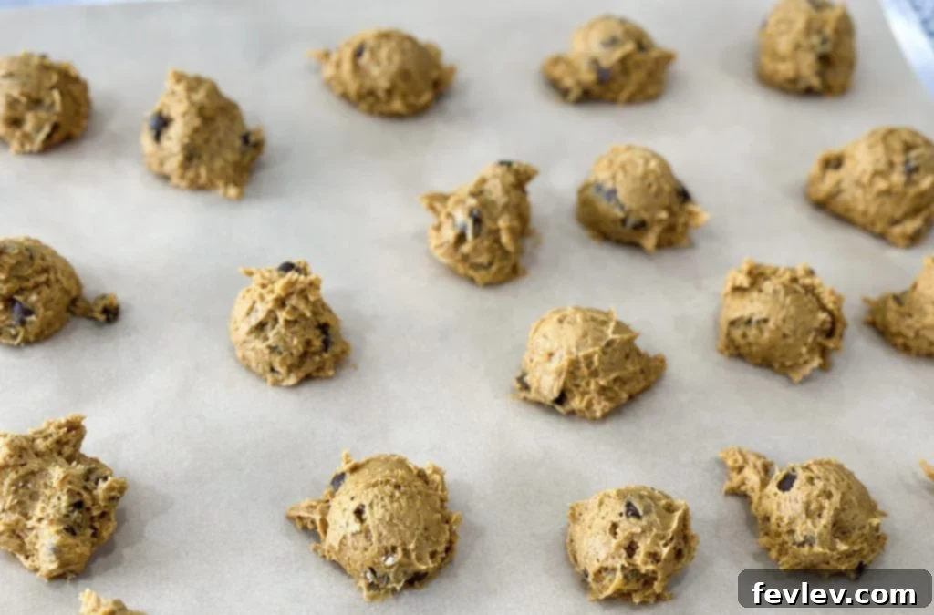 Rolled pumpkin cookie dough balls on baking sheet