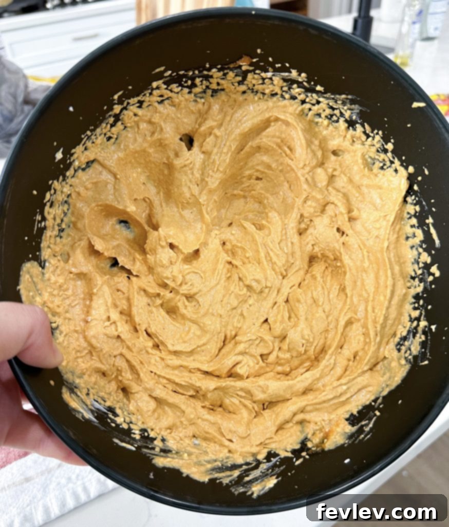 Smooth and creamy pumpkin cheesecake mixture in a bowl, ready for layering.