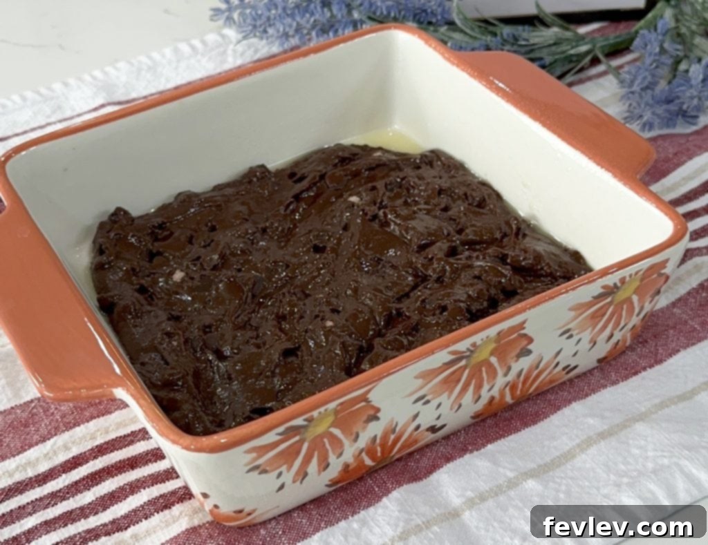 First layer of brownie batter spread evenly in a baking dish.