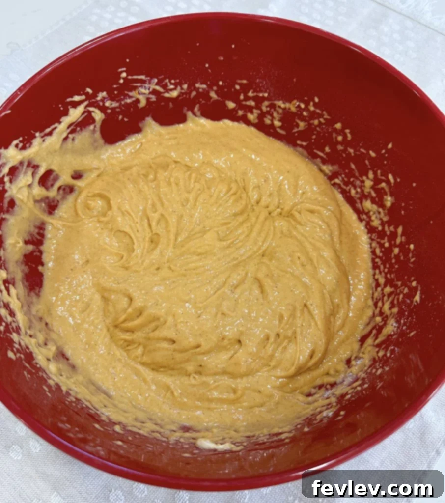 Mixing the pumpkin honey bun cake batter in a large bowl