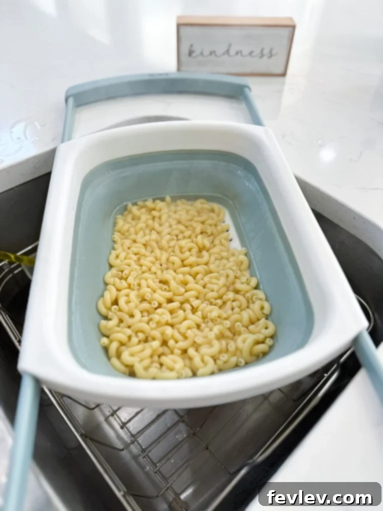 A large pot of boiling water with pasta cooking inside, ready for the first step of the pasta with beans recipe.