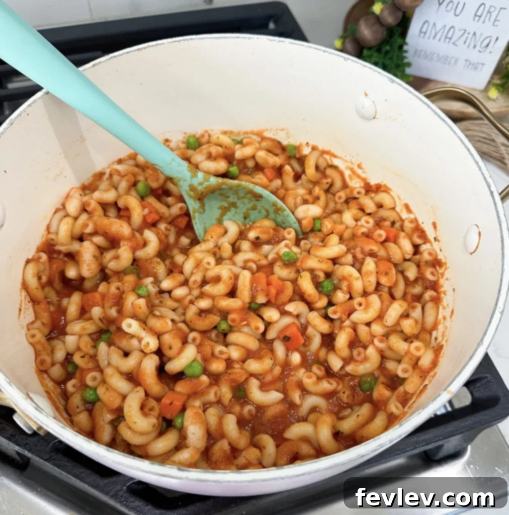 Close-up of the finished pasta with beans dish, with pasta and sauce mixed, ready to be served from the pot.
