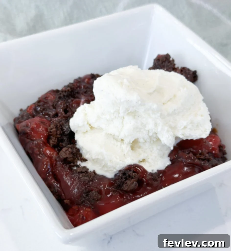 Close-up of baked Black Forest Dump Cake with a spoonful ready to be served, garnished with fresh cherries