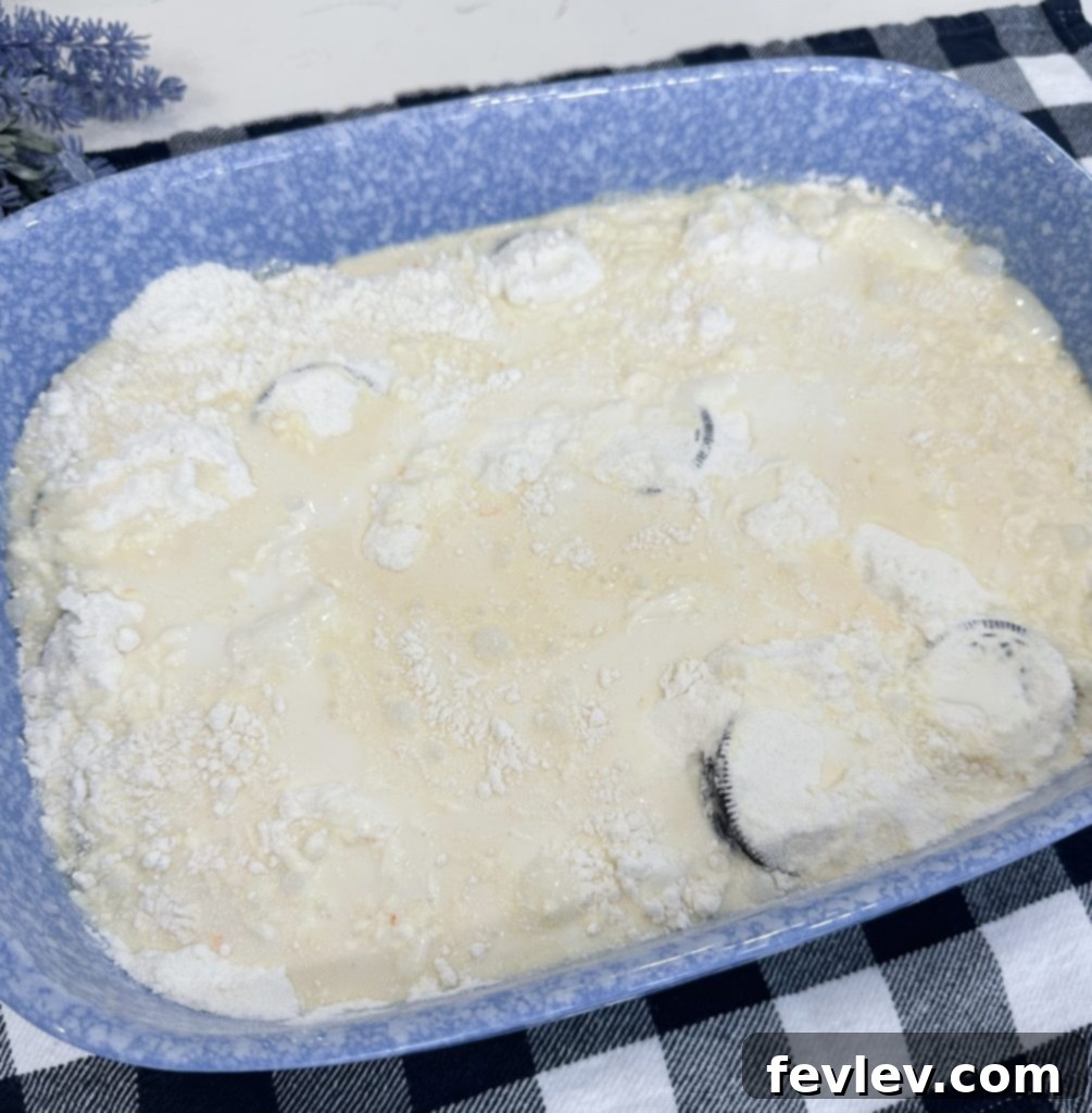 Dry yellow cake mix sprinkled over the Oreo base in a baking pan