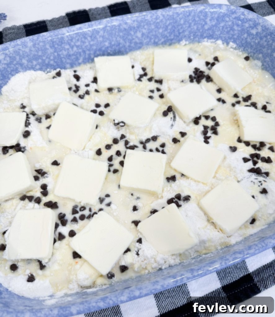 Thinly sliced butter placed over the cake mix and milk mixture in the baking dish