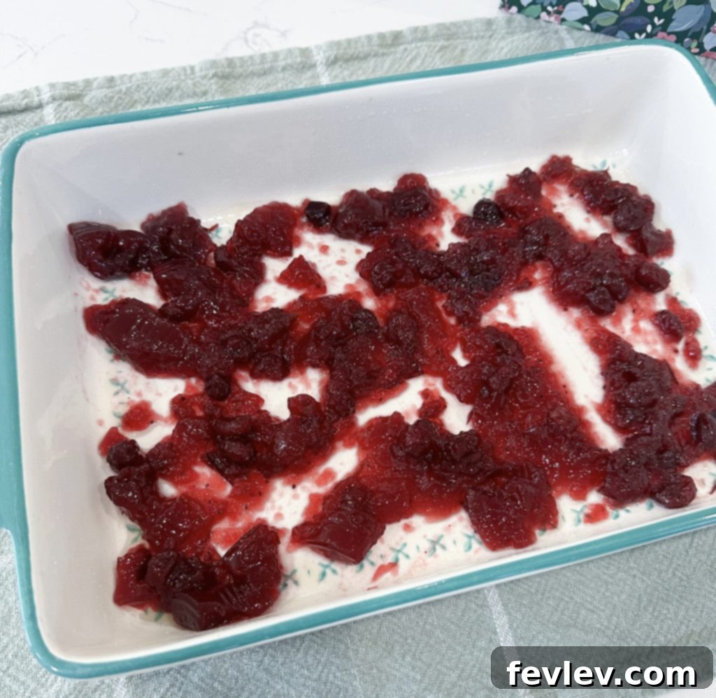 Festive Apple Cranberry Dump Cake 4 Spreading cranberry sauce in baking dish for dump cake
