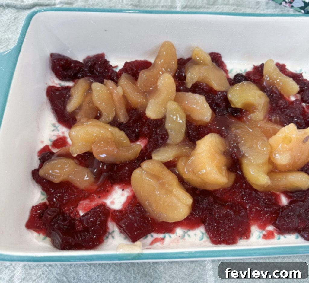 Festive Apple Cranberry Dump Cake 5 Spreading apple pie filling over cranberry sauce