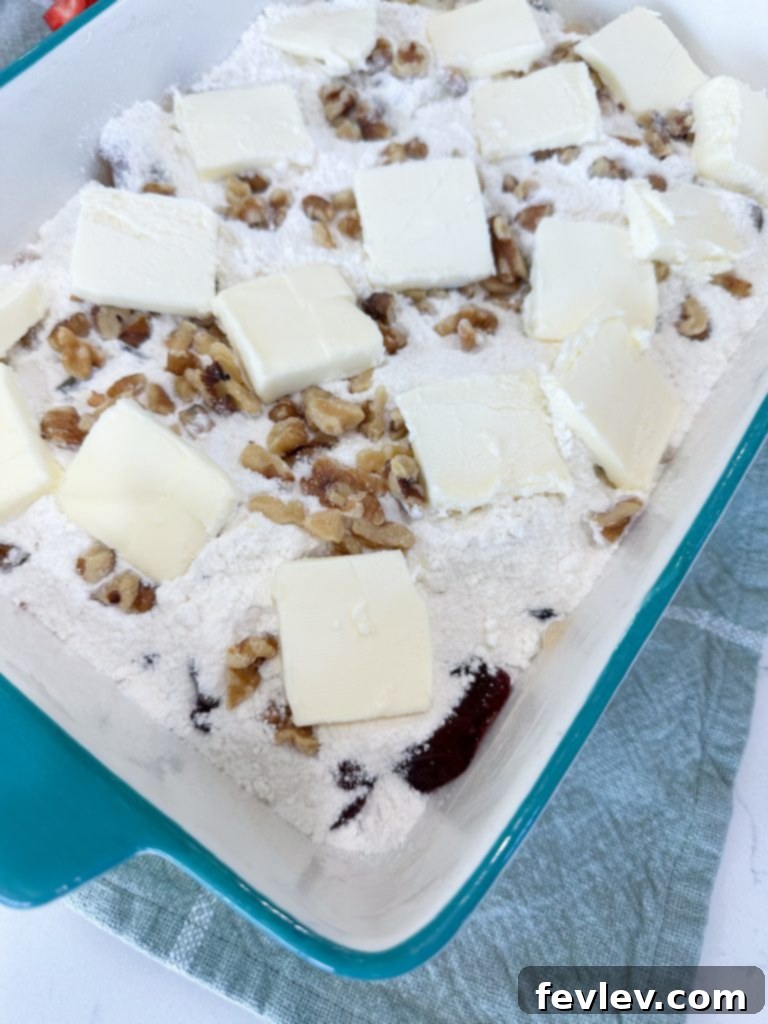Festive Apple Cranberry Dump Cake 6 Layering cake mix, walnuts, and butter for Apple Cranberry Dump Cake