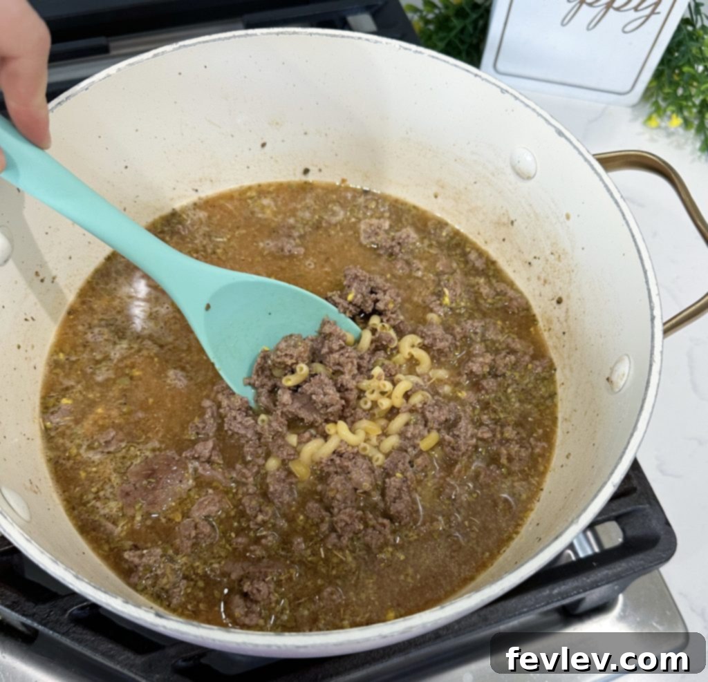 Draining grease from cooked ground beef in a pot