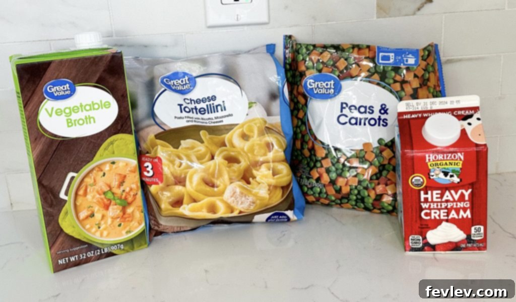 Collection of ingredients for Creamy Tortellini Soup including vegetable broth, frozen peas and carrots, cheese tortellini, heavy cream, salt, pepper, and Italian seasoning.