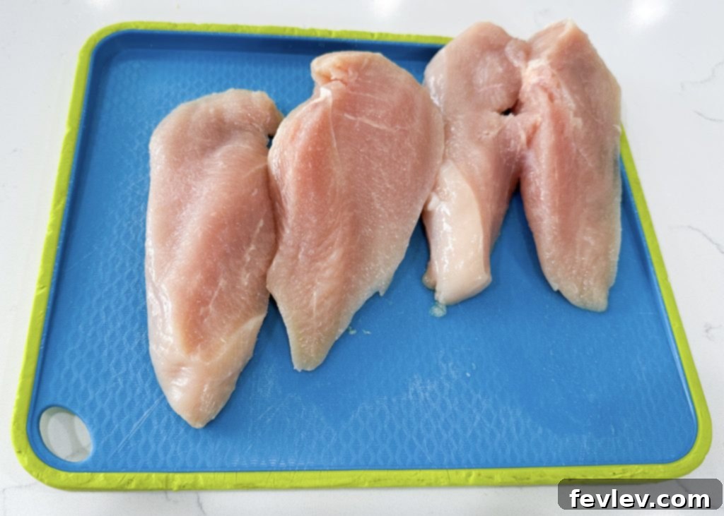 Sliced chicken breasts placed in a baking dish, ready for seasoning.