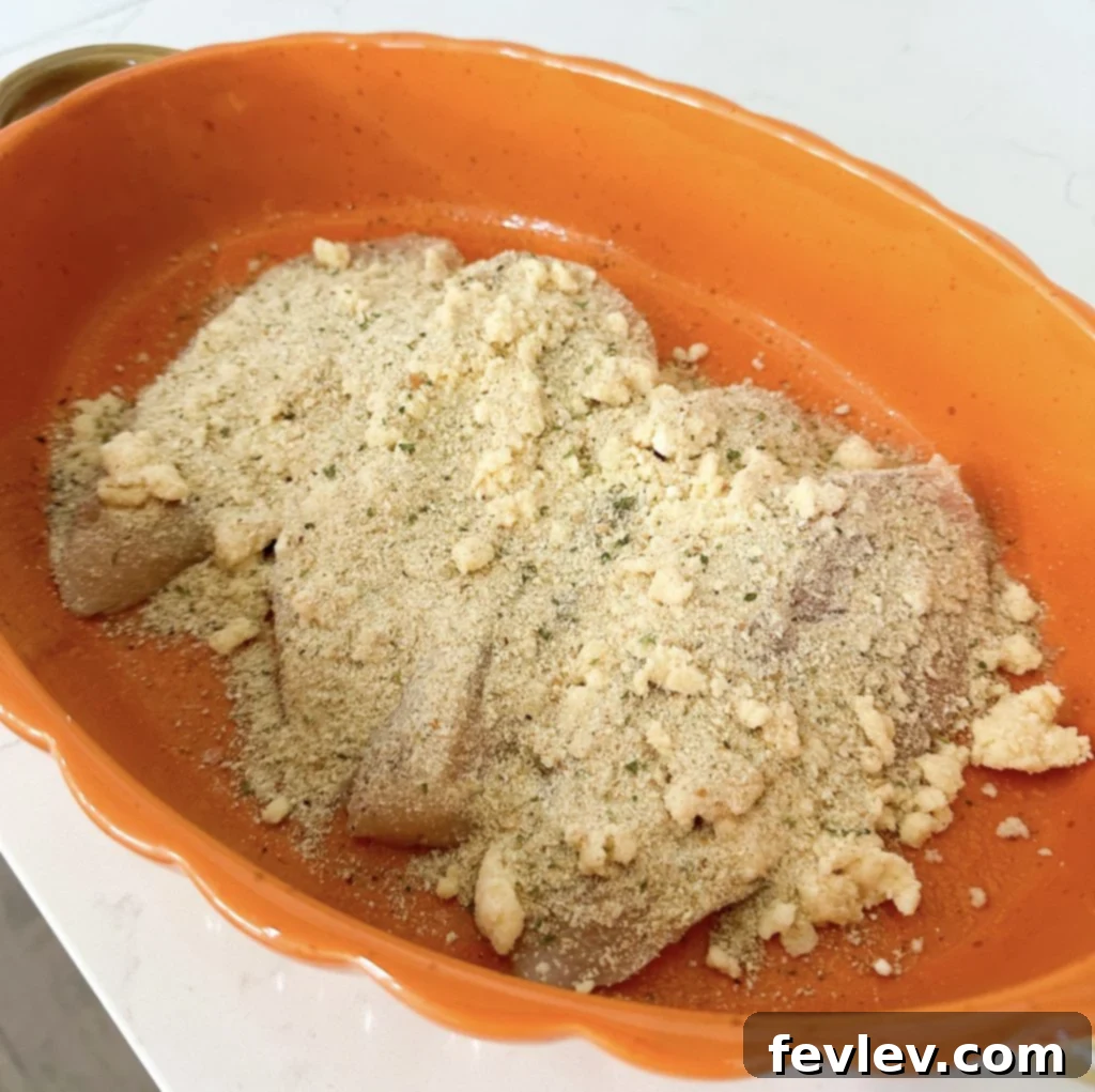 Panko breadcrumbs generously sprinkled over the mayonnaise-coated chicken breasts.