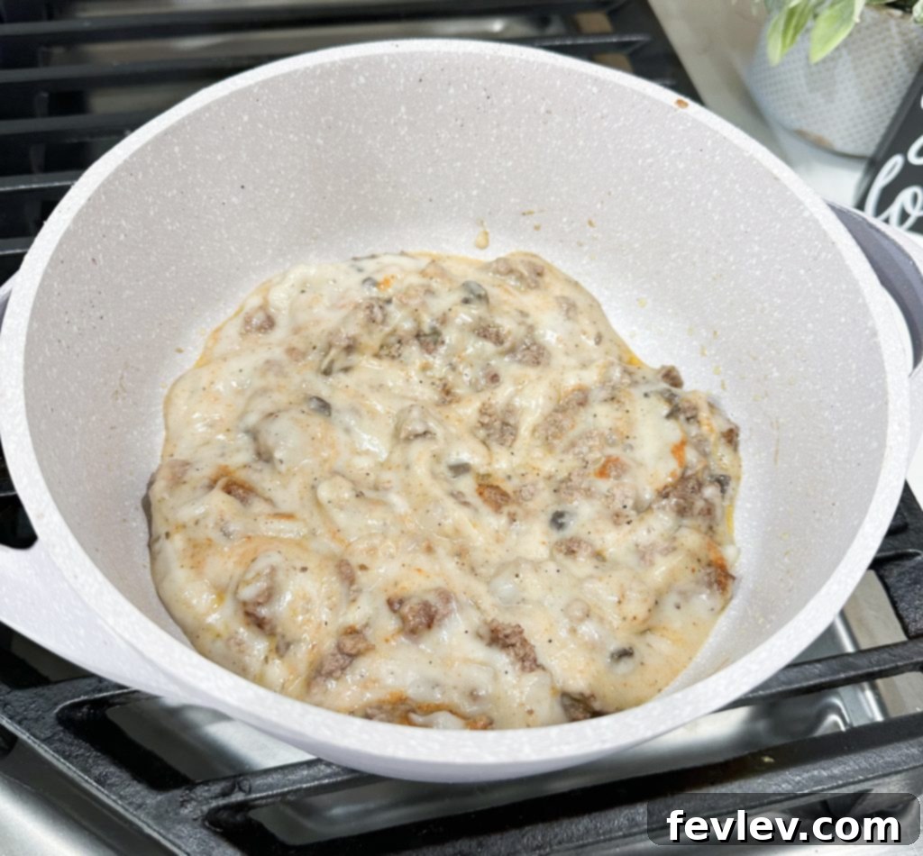 spreading ground beef mixture in baking dish for tater tot casserole