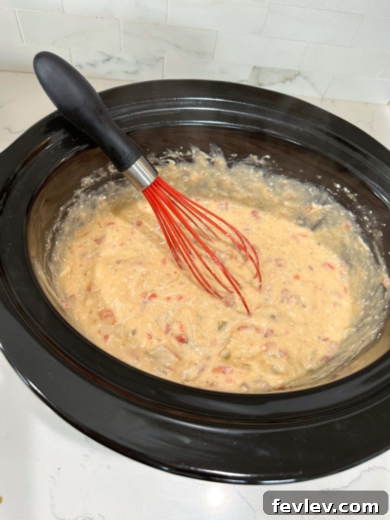Creamy Slow Cooker Chicken Spaghetti 6 Cooked spaghetti and shredded cheese added to the creamy chicken sauce in the slow cooker, ready for final mixing.