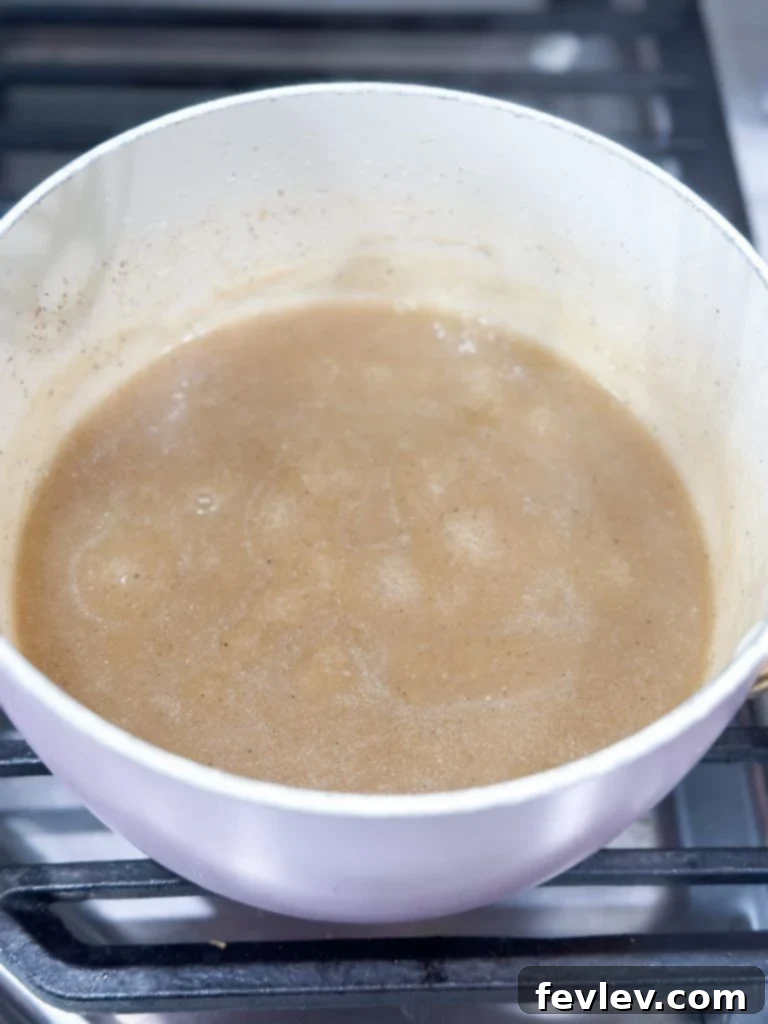 Ultimate Slow Cooker Turkey Dinner with Creamy Mash 8 Homemade gravy thickening in a saucepan