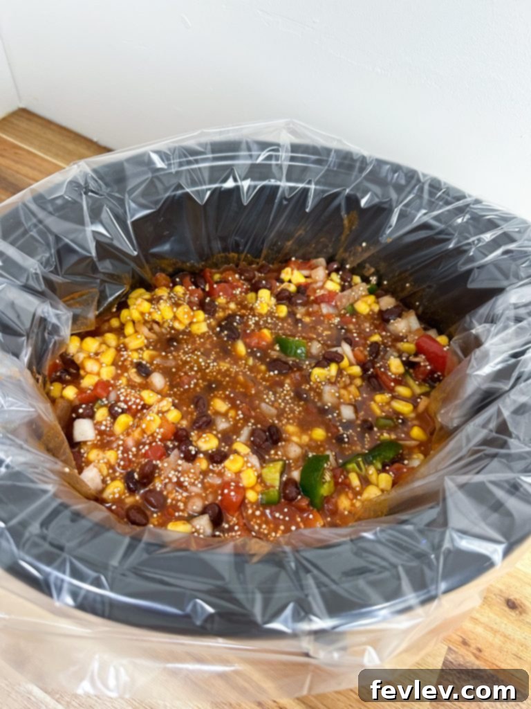 All ingredients for Slow Cooker Enchilada Quinoa mixed in a slow cooker pot