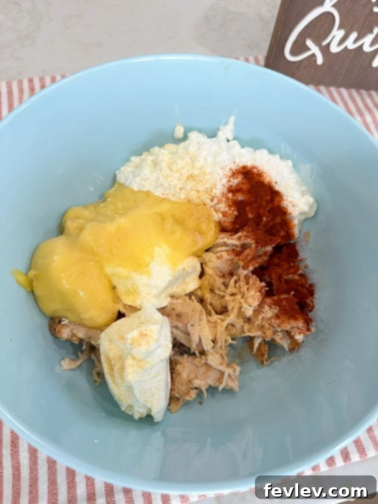 mixing famous million dollar chicken casserole ingredients in a large bowl
