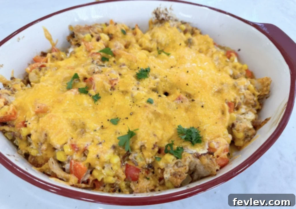 Rotisserie chicken and vegetable casserole mixture spread evenly in a baking dish.