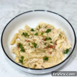 Slow cooker creamy chicken pasta topped with parsley, cheesy, spicy, and family-friendly