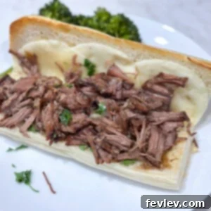 Easy slow cooker French dip roast sandwiches, piled high with tender beef and ready for dipping