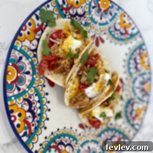 Slow Cooker Shredded Chicken Tacos, featuring seasoned chicken ready for tortillas and toppings