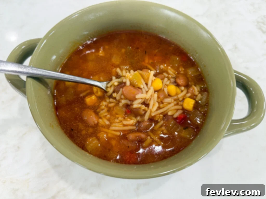 Feast for a Month: $45 Budget Dinners and Savvy Grocery Secrets 12 A steaming bowl of Spanish rice soup, garnished with fresh cilantro, offering a warm and flavorful budget-friendly meal.