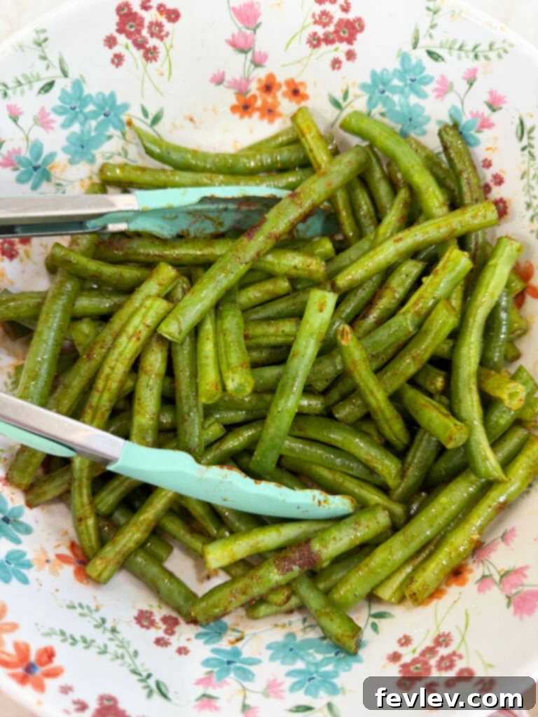 Effortless One-Pan Roasted Green Beans 2 Green beans tossed with seasonings on a sheet pan