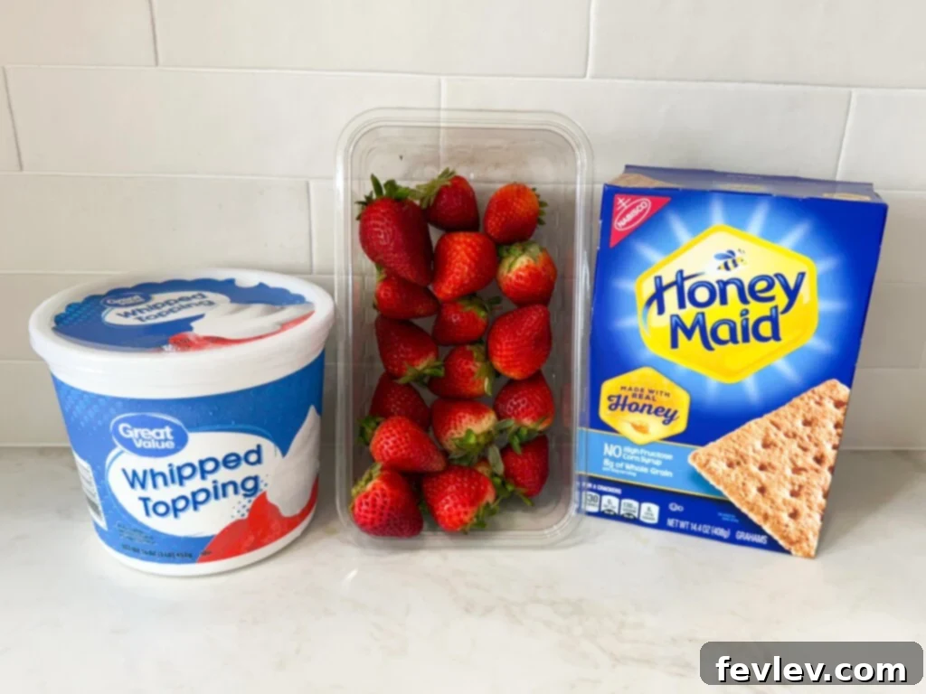 Ingredients for a No-Bake Strawberry Icebox Cake, including whipped topping, graham crackers, and fresh strawberries