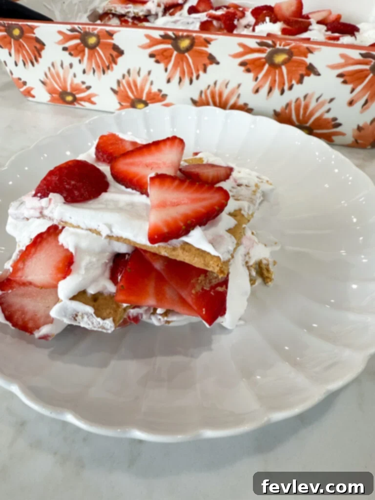Slice of easy strawberry short cake, showing off its beautiful layers