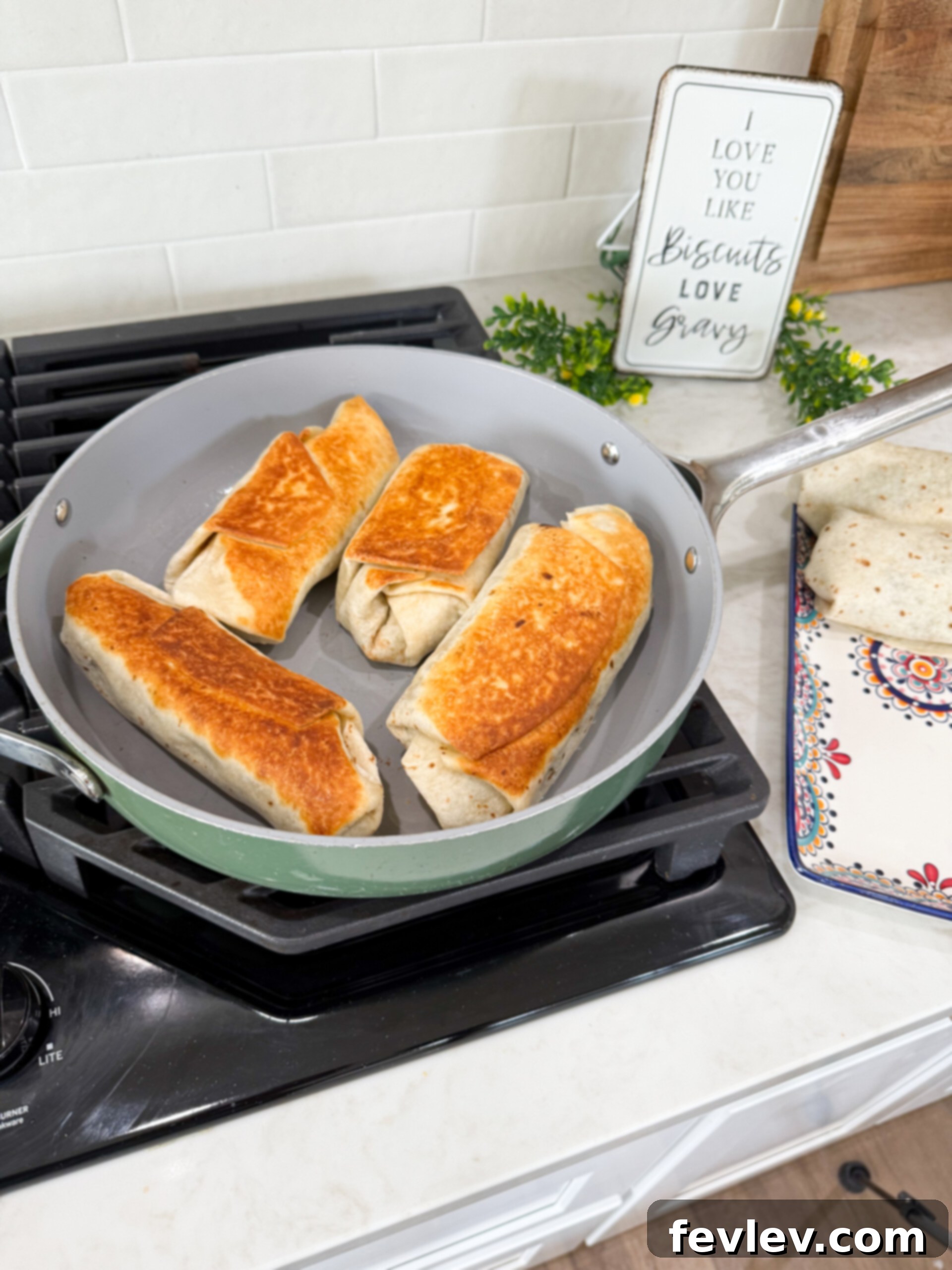 Lentil potato wraps being crisped to a golden brown in a hot skillet.