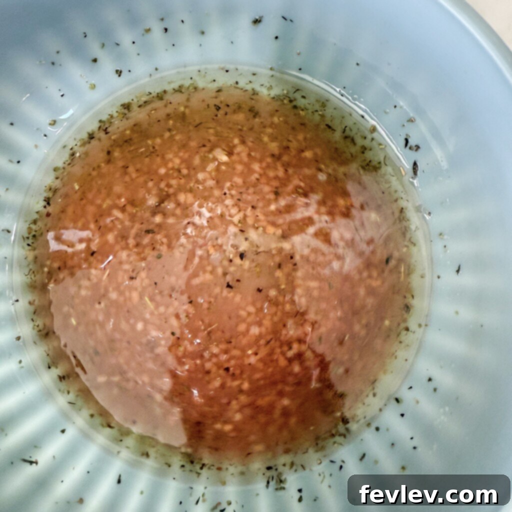 Homemade dressing for antipasto salad ingredients being whisked in a bowl