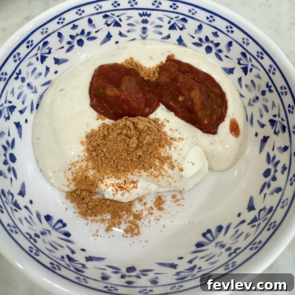 Mixing creamy ranch and salsa ingredients in a bowl