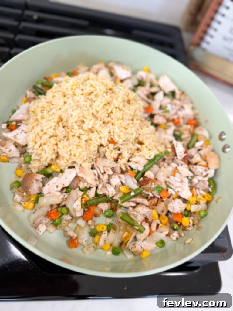 Add rice to cooked chicken and vegetables