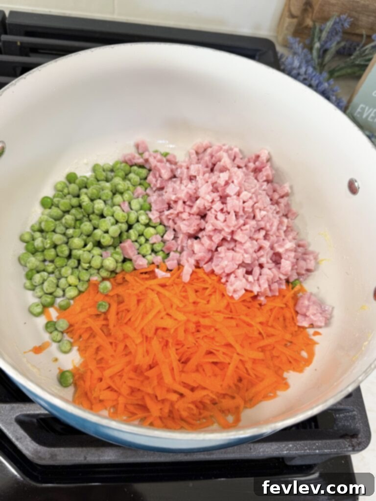 Quick and Delicious Ham Fried Rice 5 Adding peas, carrots, and ham to a hot pan