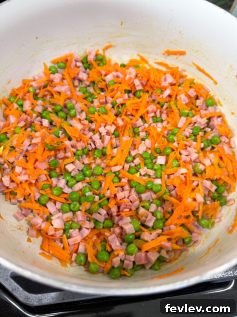 Quick and Delicious Ham Fried Rice 6 Tender veggies and ham cooking in a pan