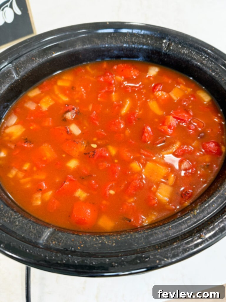 All the vegetarian chili ingredients perfectly mixed in a slow cooker.